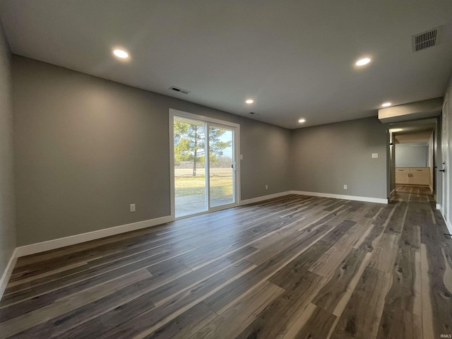 empty room featuring dark wood finished floors, baseboards, and visible vents