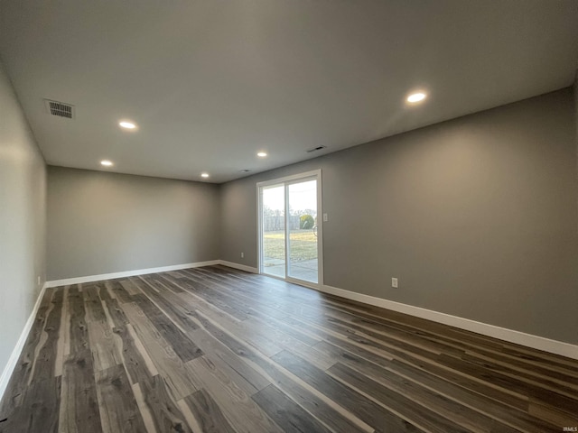 empty room featuring dark wood finished floors, visible vents, recessed lighting, and baseboards