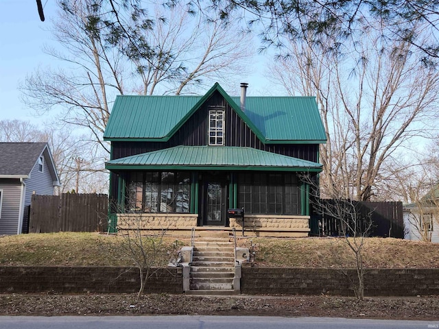 view of front of property with metal roof, a porch, and fence