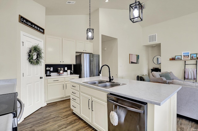 kitchen featuring a sink, stainless steel appliances, decorative light fixtures, and light countertops