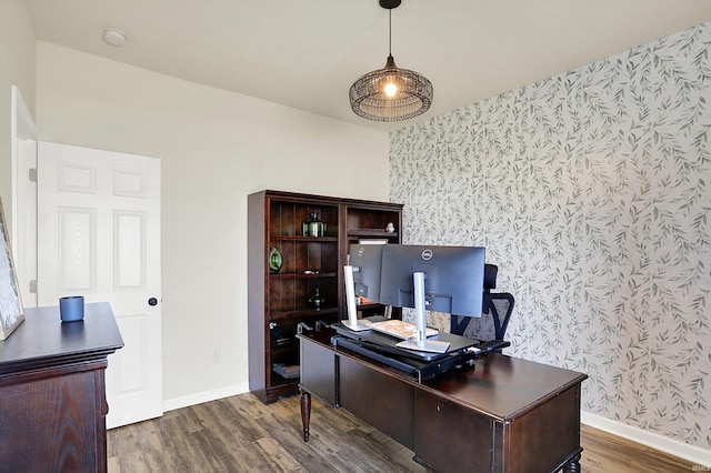 office with baseboards, dark wood finished floors, an accent wall, and wallpapered walls