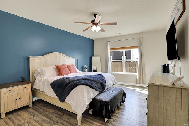 bedroom with baseboards, a ceiling fan, and dark wood-style flooring