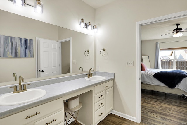 bathroom featuring double vanity, wood finished floors, ensuite bathroom, and a sink