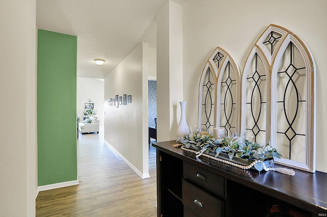 corridor with wood finished floors and baseboards