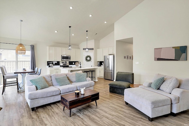 living area featuring recessed lighting, light wood-type flooring, and high vaulted ceiling