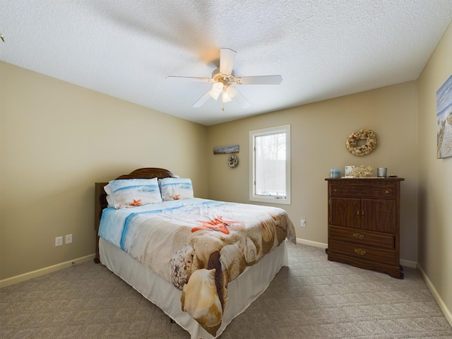 bedroom with light colored carpet, baseboards, and a textured ceiling