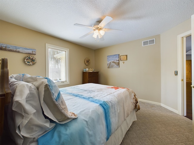 bedroom with visible vents, a textured ceiling, baseboards, and carpet