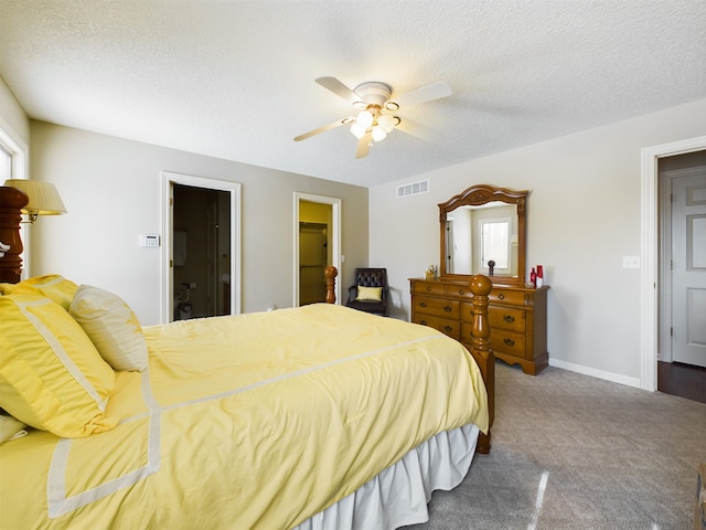 carpeted bedroom featuring visible vents, ceiling fan, a textured ceiling, and baseboards