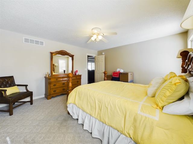 bedroom with visible vents, baseboards, ceiling fan, carpet floors, and a textured ceiling