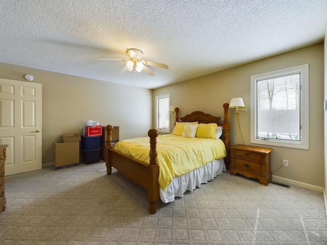 bedroom with light carpet, multiple windows, and baseboards