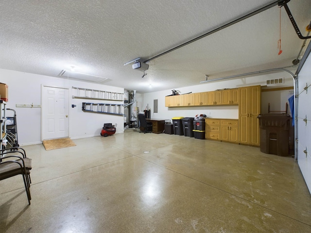 garage with electric panel, visible vents, baseboards, and a garage door opener