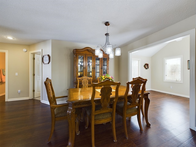 dining space featuring dark wood-style floors, baseboards, and a chandelier