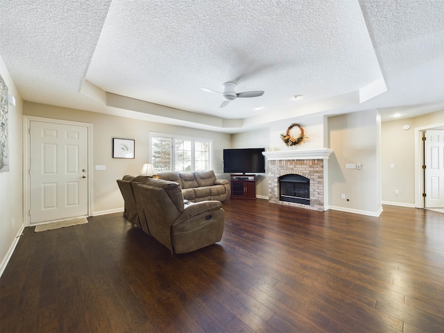 living area with baseboards, dark wood-style floors, and a ceiling fan