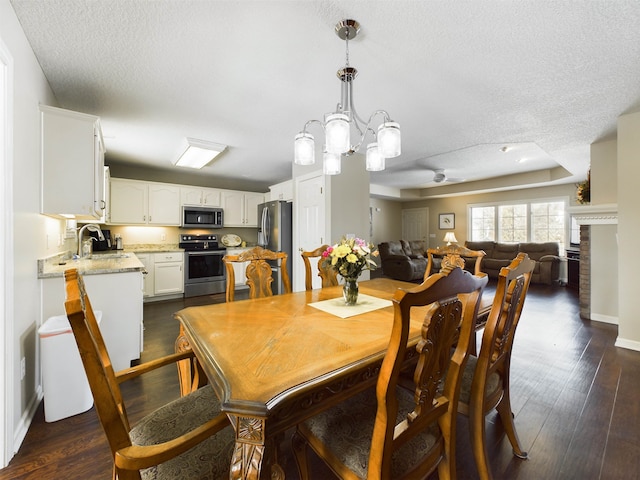 dining room featuring a textured ceiling, baseboards, and dark wood-style flooring