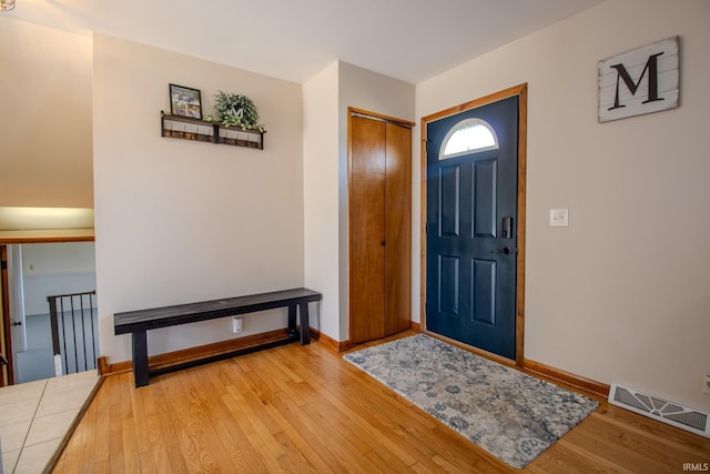 foyer entrance featuring visible vents, wood-type flooring, and baseboards