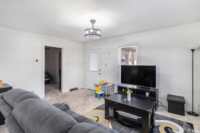 living area featuring visible vents, baseboards, and carpet