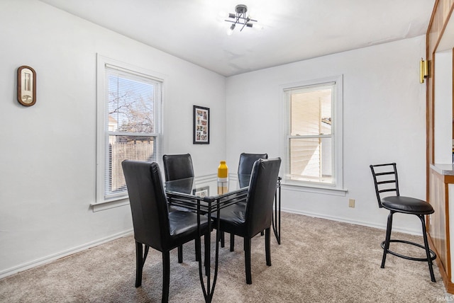 dining area featuring baseboards and light colored carpet