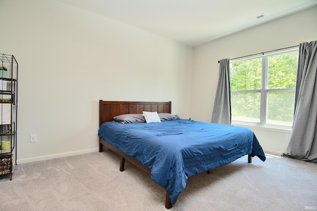 bedroom with visible vents, baseboards, and light colored carpet