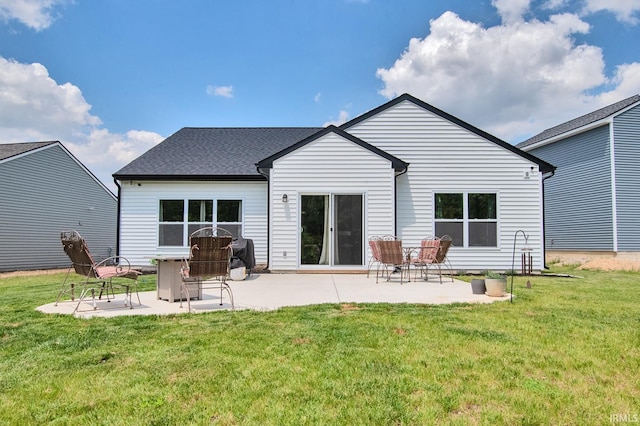 rear view of house with a patio and a lawn