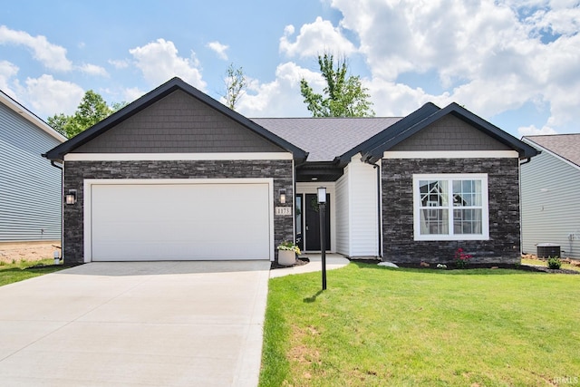 view of front of property featuring central air condition unit, stone siding, concrete driveway, a front yard, and a garage