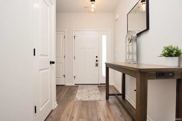 entryway with visible vents, baseboards, and wood finished floors