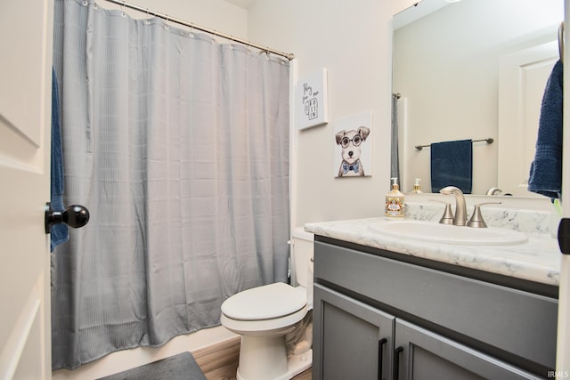 bathroom with vanity, shower / bath combination with curtain, and toilet