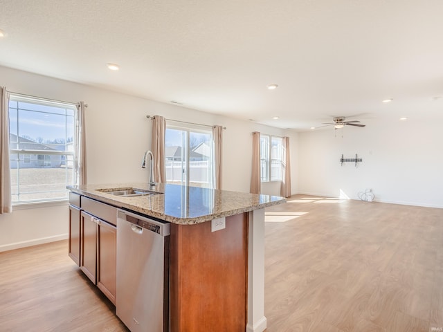 kitchen featuring a center island with sink, light wood-type flooring, a sink, dishwasher, and open floor plan