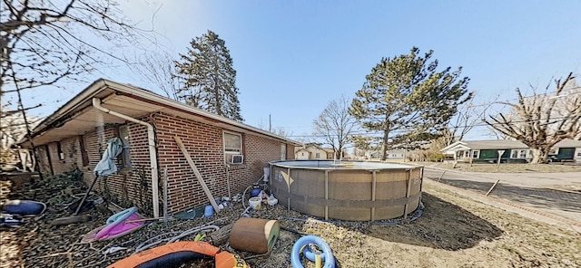 view of home's exterior featuring brick siding and an outdoor pool