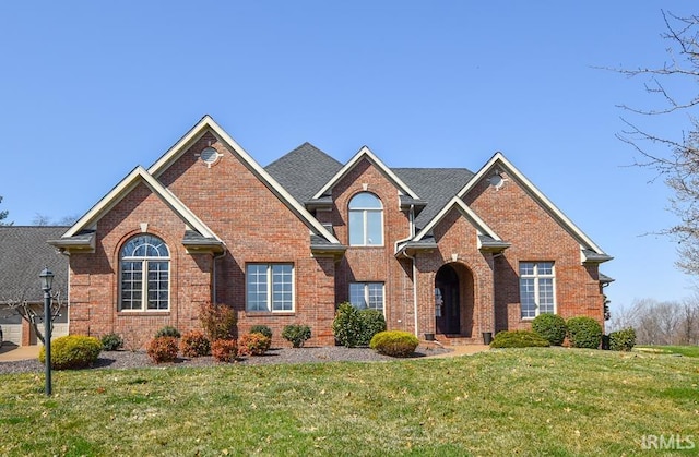 view of front of home featuring a front yard and brick siding