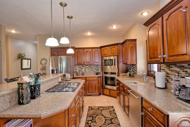 kitchen with backsplash, pendant lighting, light tile patterned floors, appliances with stainless steel finishes, and a sink