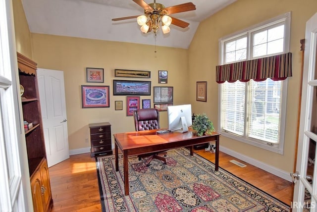 office space with visible vents, a ceiling fan, light wood-type flooring, and baseboards