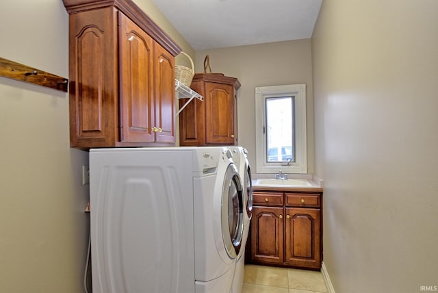 laundry room with baseboards, light tile patterned flooring, cabinet space, a sink, and washer and dryer