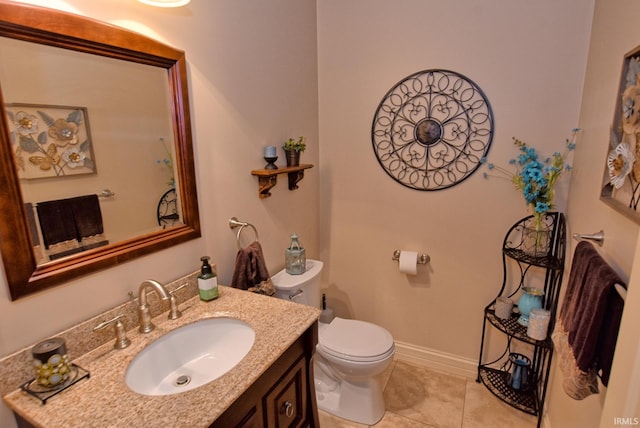 half bathroom featuring tile patterned floors, toilet, vanity, and baseboards