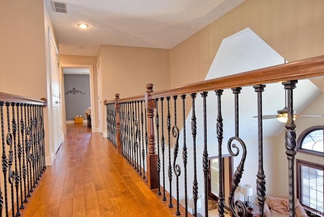 hallway featuring baseboards, visible vents, and light wood-type flooring