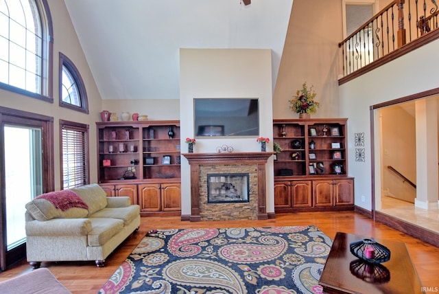 living room with a high ceiling, wood finished floors, and a fireplace