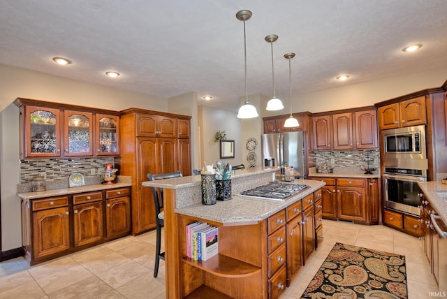 kitchen with open shelves, a center island, appliances with stainless steel finishes, glass insert cabinets, and hanging light fixtures