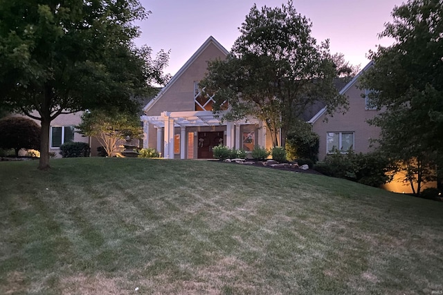 view of front of property with a pergola and a yard