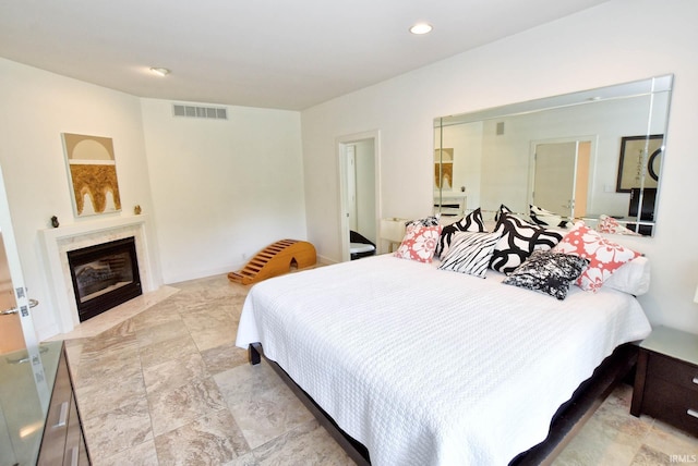 bedroom with recessed lighting, visible vents, and a premium fireplace