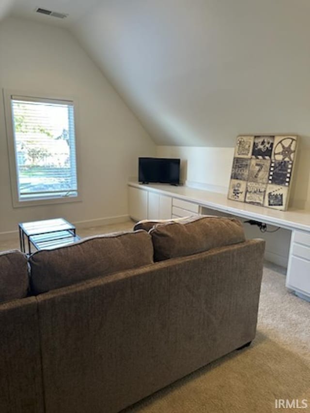 living room with visible vents, light colored carpet, and vaulted ceiling