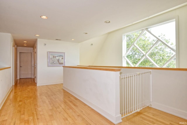 corridor featuring recessed lighting, baseboards, light wood-style flooring, and an upstairs landing