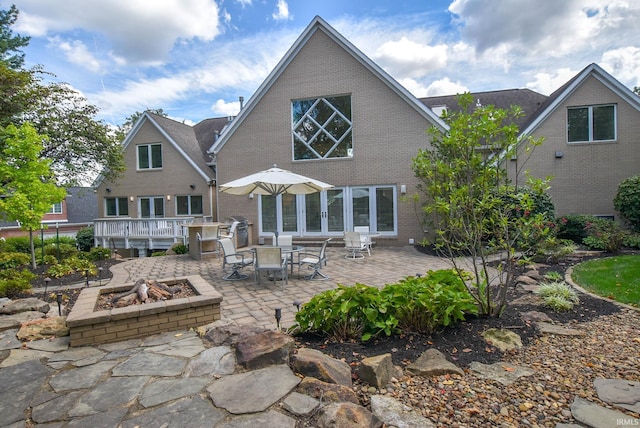 back of house featuring a patio area, a fire pit, and brick siding