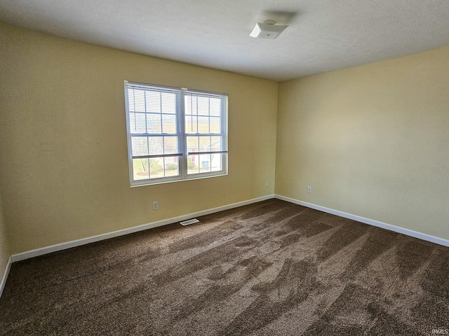 empty room with baseboards and dark carpet