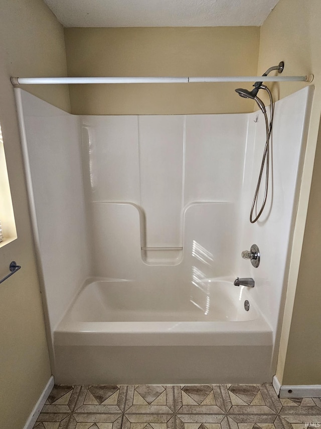 bathroom featuring baseboards and shower / washtub combination