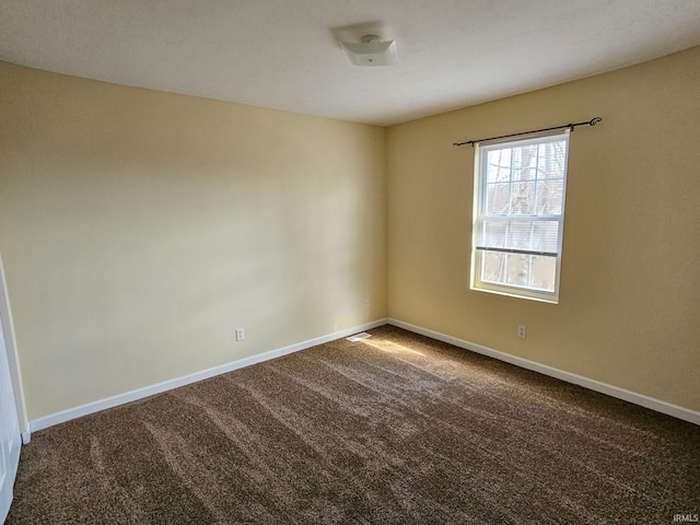 carpeted spare room featuring baseboards