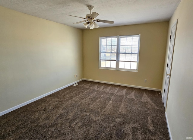 unfurnished room with a textured ceiling, baseboards, dark colored carpet, and ceiling fan