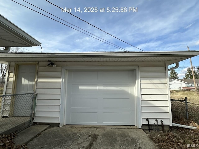 garage with fence and driveway