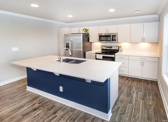 kitchen featuring an island with sink, dark wood-style flooring, ornamental molding, a sink, and appliances with stainless steel finishes