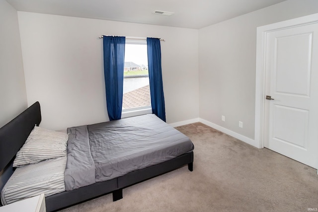 carpeted bedroom featuring visible vents and baseboards