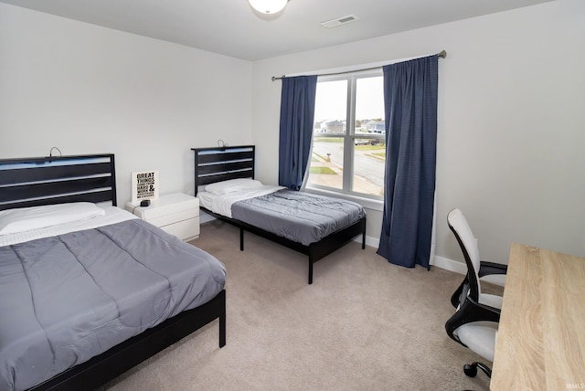 bedroom with visible vents, light carpet, and baseboards