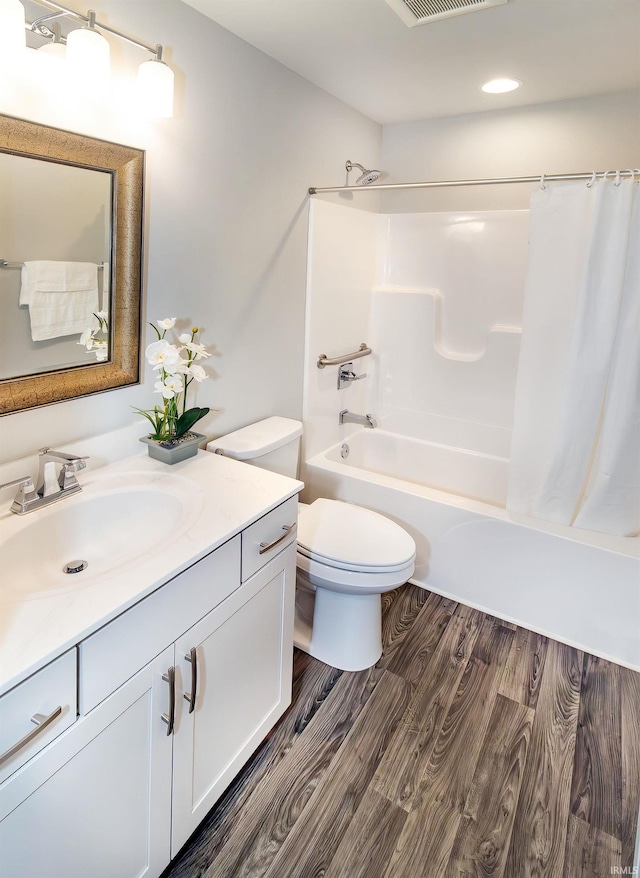 bathroom with vanity, wood finished floors, visible vents, toilet, and shower / tub combo with curtain